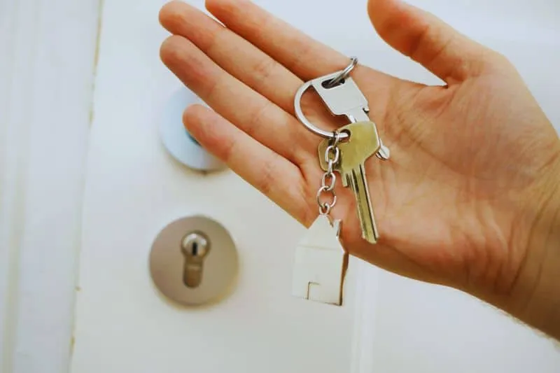 A buyer's hand holding their new home's keys.
