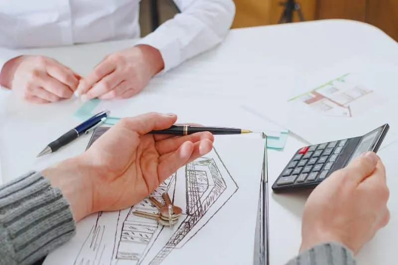 When you have enough money to buy a house with cash, your agent will have a better position for negotiating a lower price. Here, a realtor is explaining to their client the purchase price they've managed to negotiate for them.